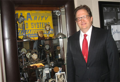 Matt O'Bryan standing next to a display case of vintage sound equipment